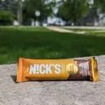 Photo of Nick's Keto Protein Bar sitting on brick retaining wall.